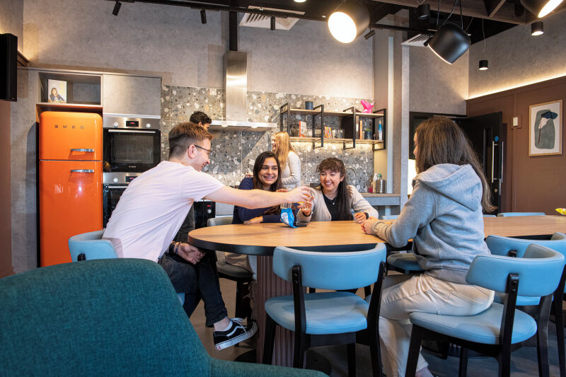 Students in accommodation cheering with glasses