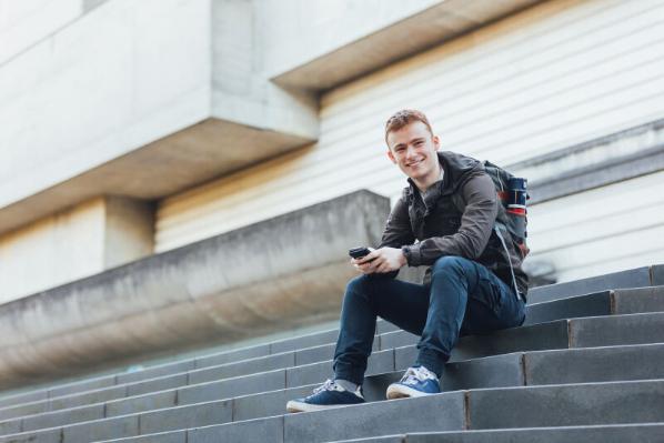 Student Conor sits on the steps in front of the Ulster Museum