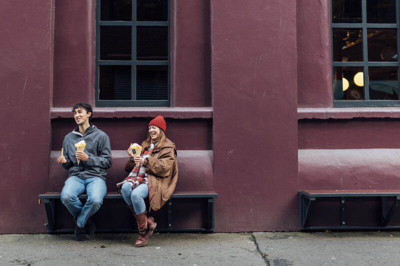Students Lucas and Lana sitting outside The Watson bar