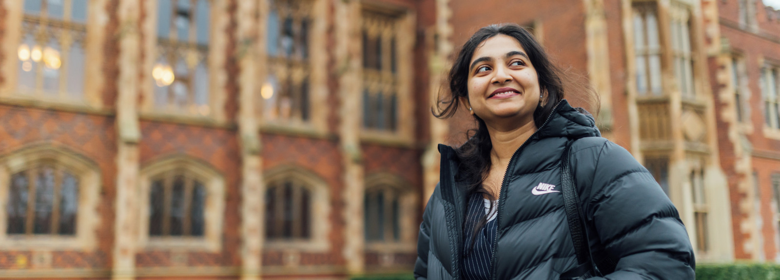 Student Sanjana walking past the front of the Lanyon